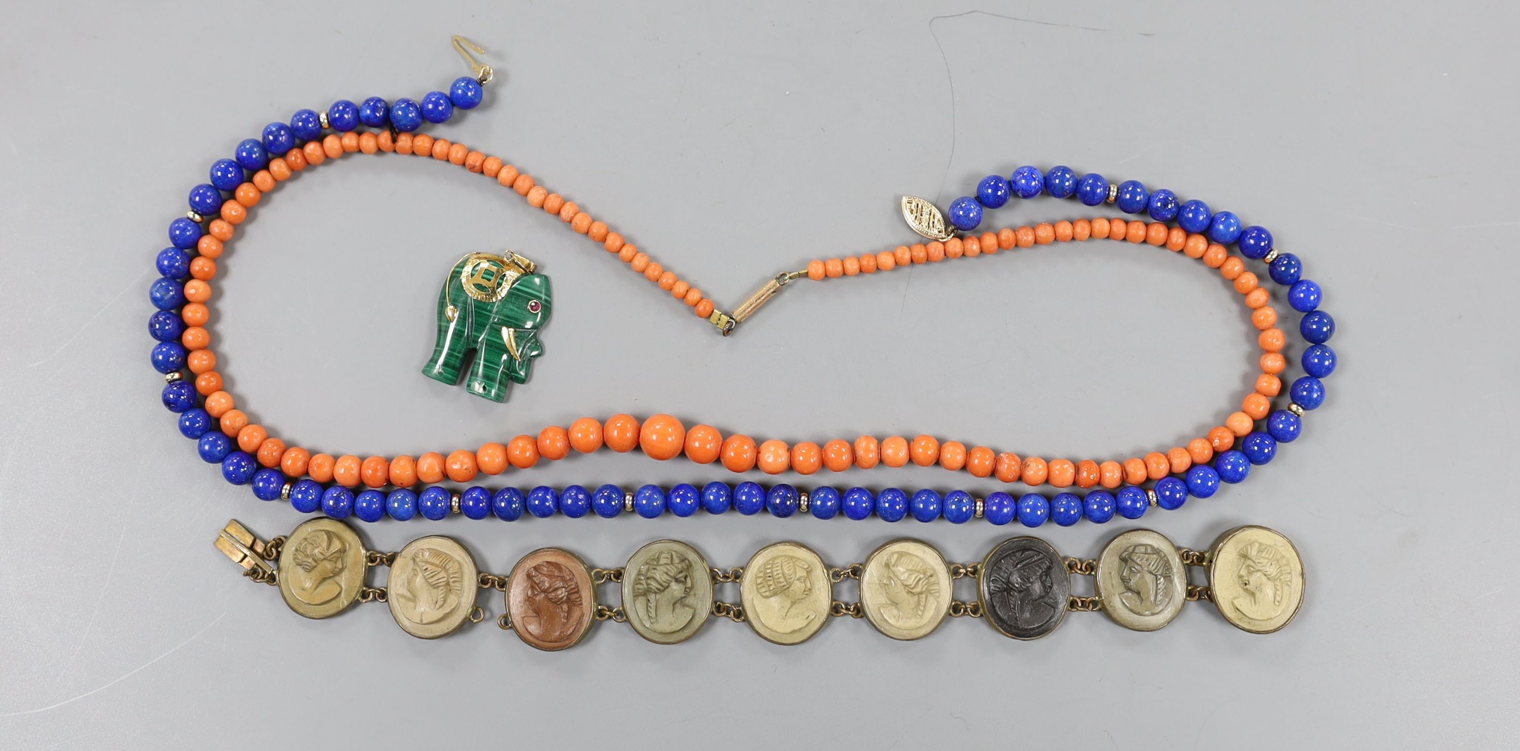 A Victorian gilt metal and lava cameo set bracelet, a 585 yellow metal mounted malachite elephant pendant and two necklaces, coral and lapis lazuli with 375 clasp.
